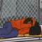 A drawing of an unhoused man laying outside of a prison