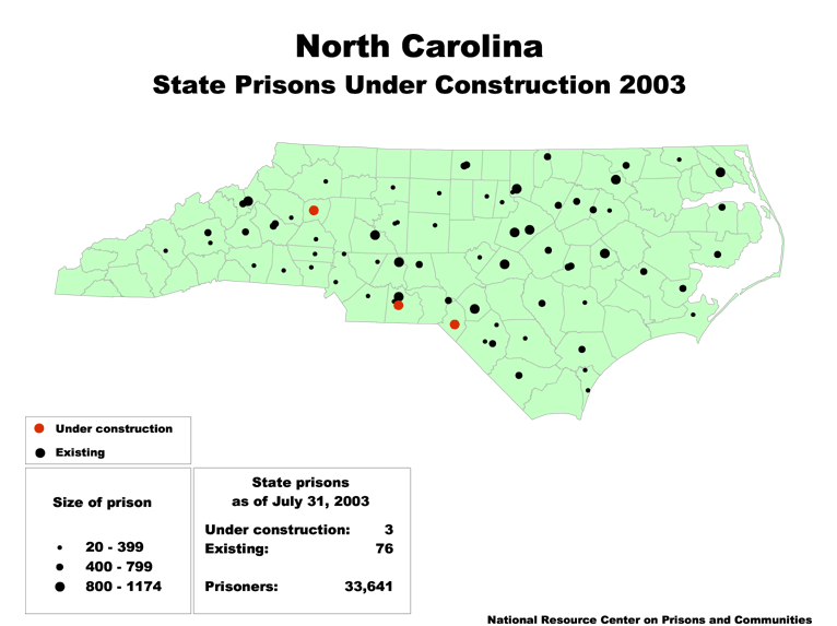 A map of North Carolina, with its existing state prisons marked by black dots and under-construction state prisons marked by red dots. The size of each dot is based on the size of the prison.